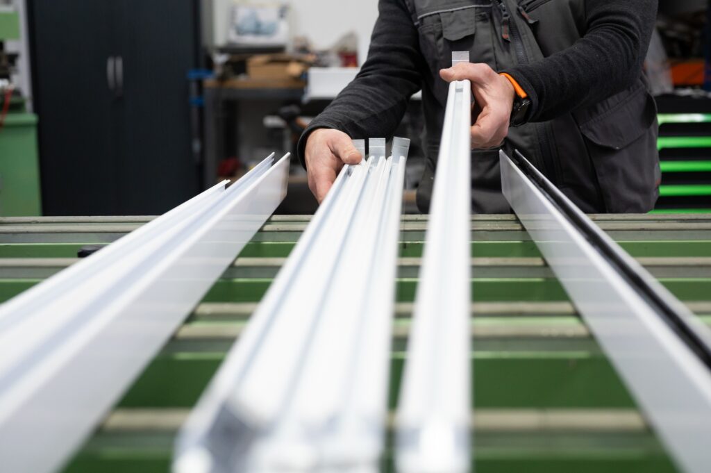 Carpenter working with aluminum profiles in workshop
